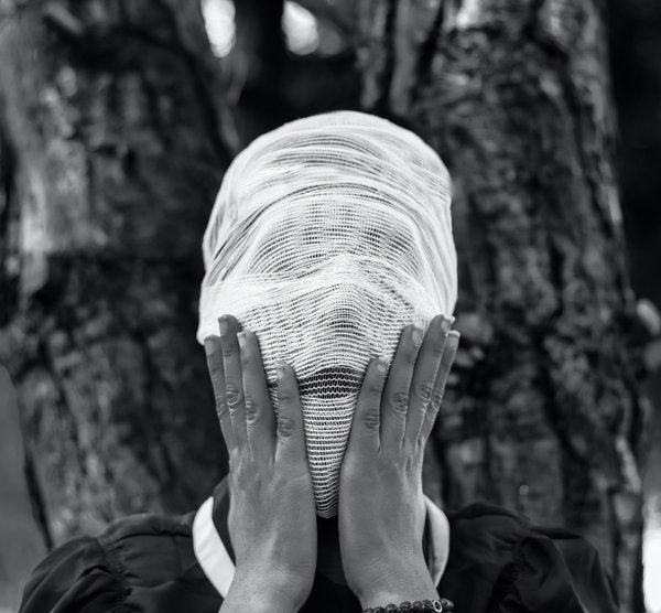 Woman with face covered by white cloth